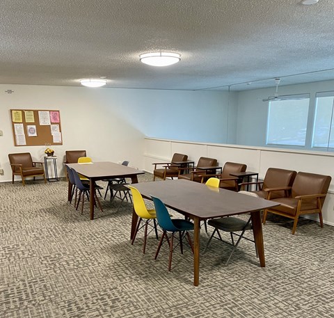 A conference room with a carpeted floor and a whiteboard on the wall.