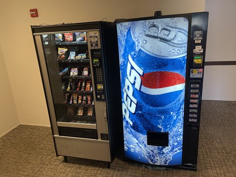 two vending machines next to each other next to a soda bottle