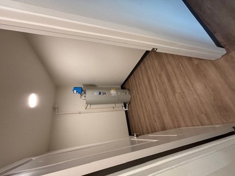A white air conditioning unit is installed on a wooden wall.