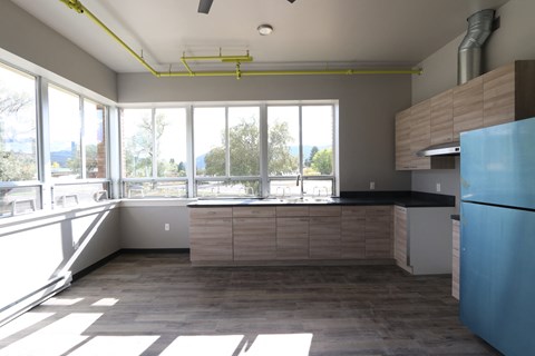 A kitchen with a blue refrigerator and wooden cabinets.