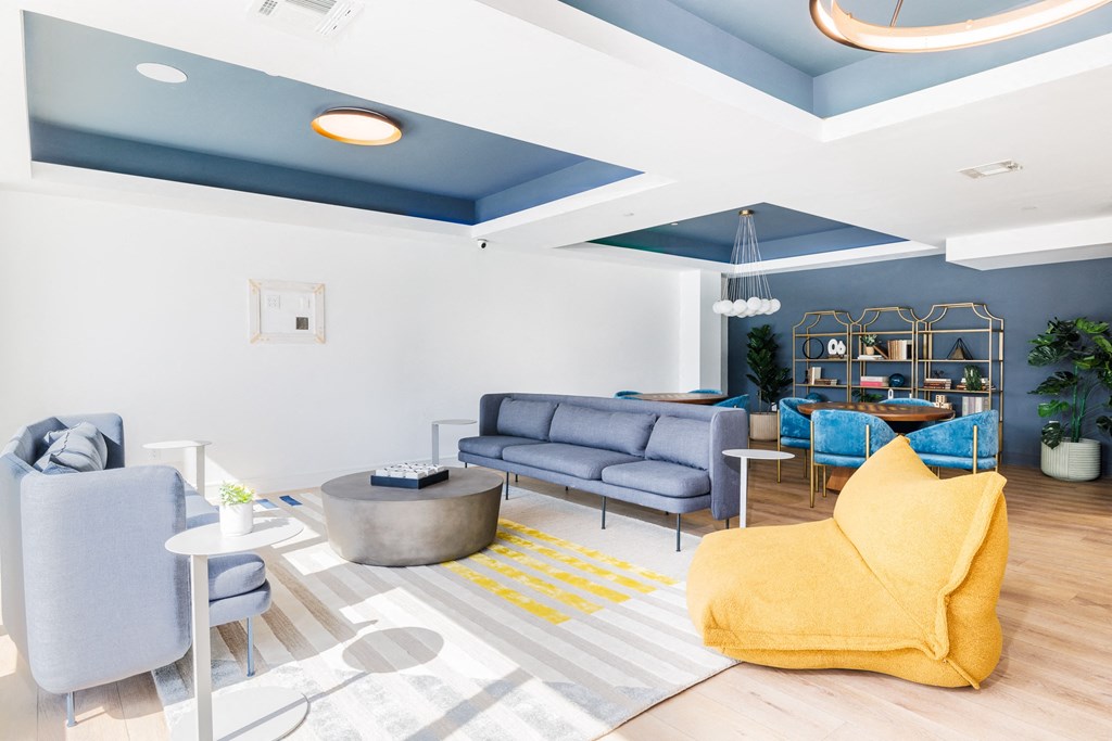 a living room with blue and yellow furniture and a blue ceiling