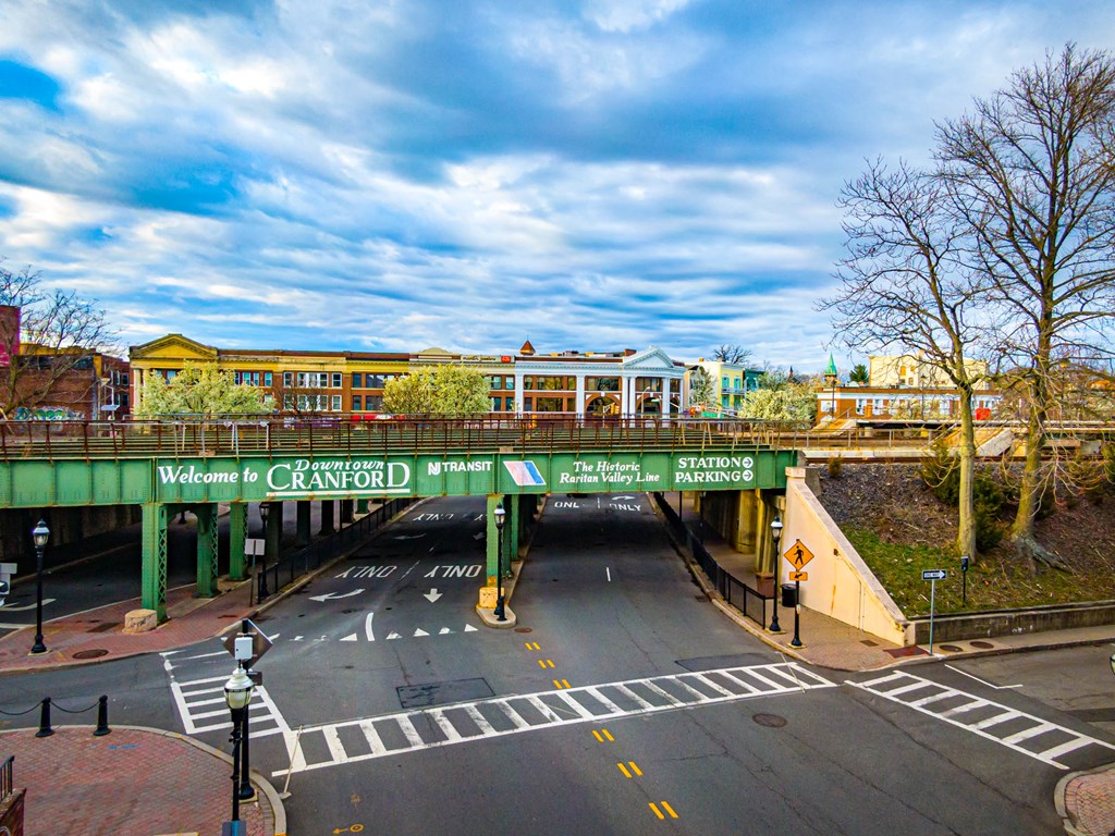 A street view of a city with a bridge and buildings in the background.