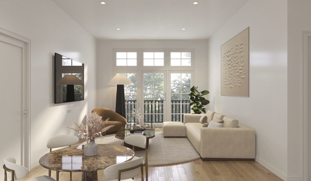 A modern living room with a brown sofa, a round table, and a large window.