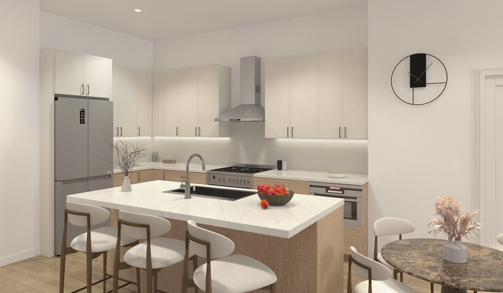 A modern kitchen with a refrigerator, sink, and bar stools.