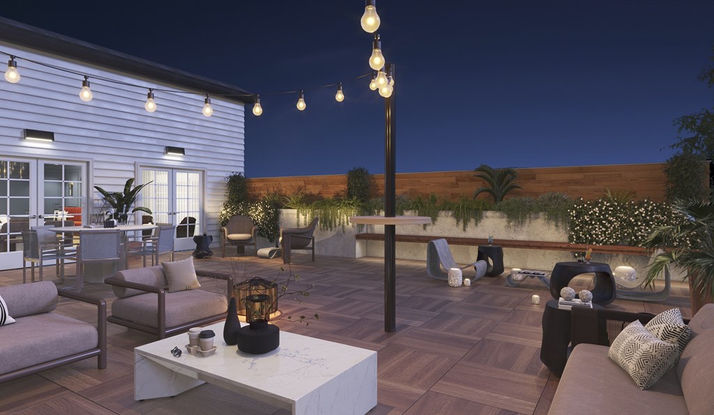 A patio with a table, chairs, and string lights.