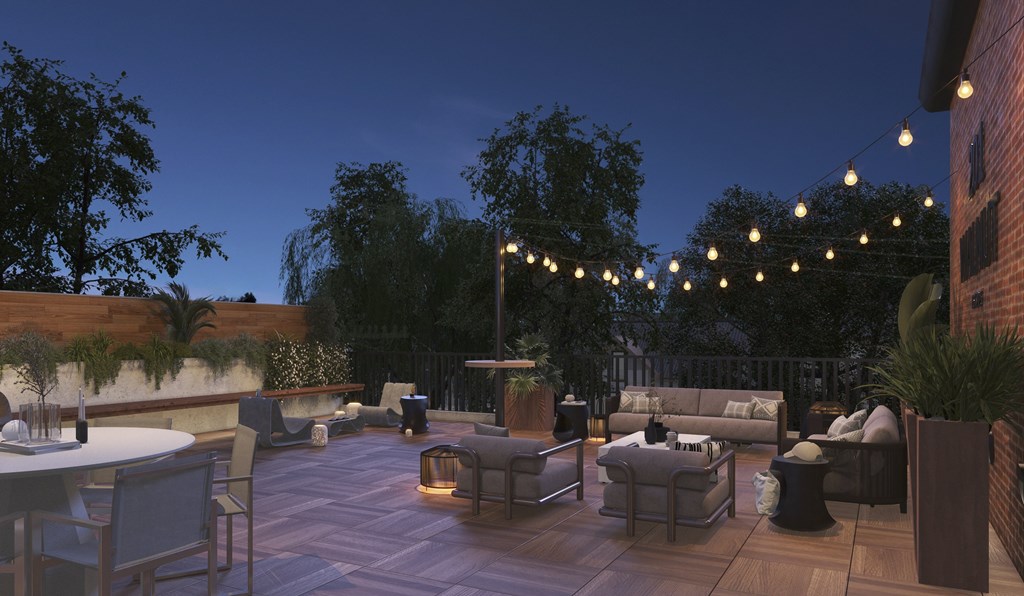 A patio with a table, chairs, and string lights.