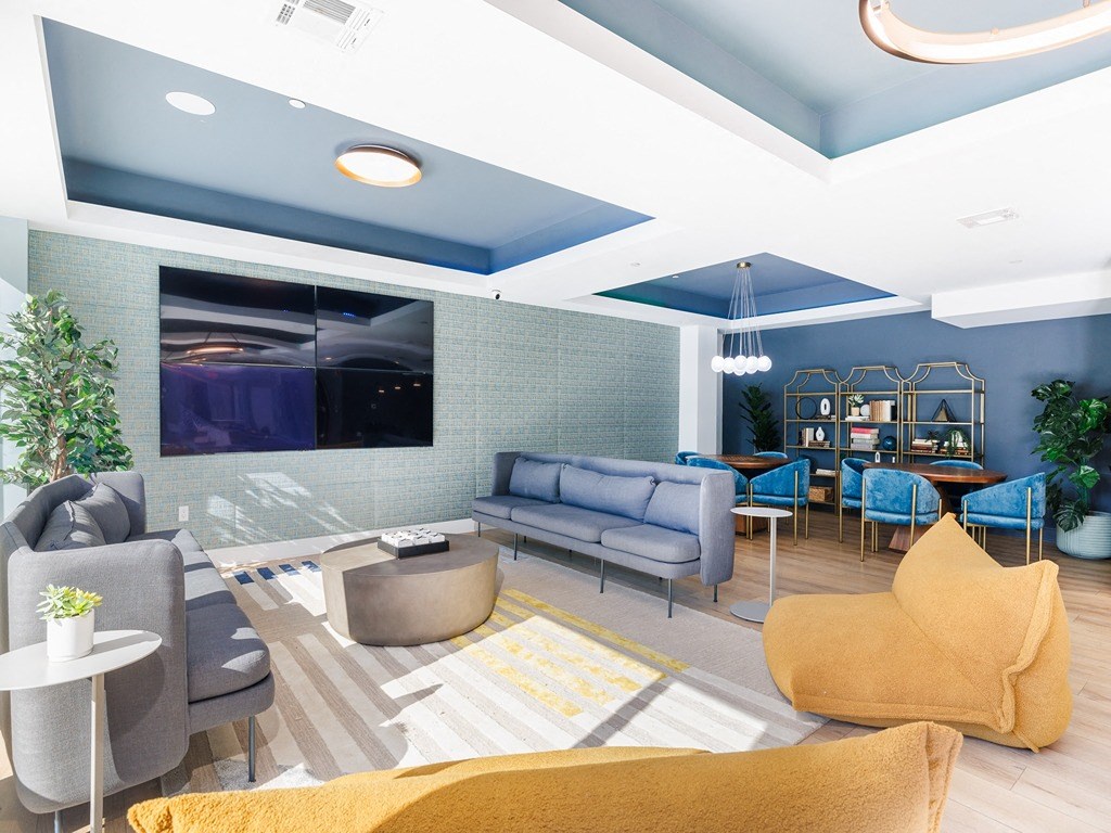 a living room with blue walls and yellow couches and chairs