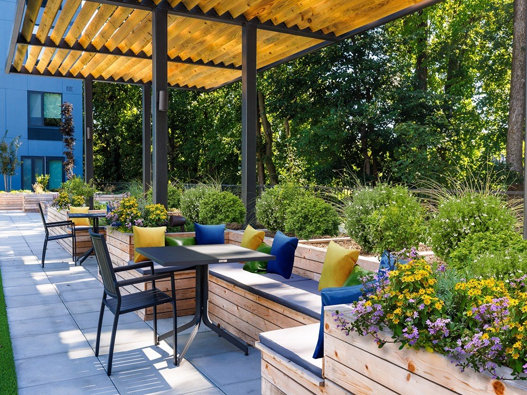 a patio with tables and chairs and a pergola