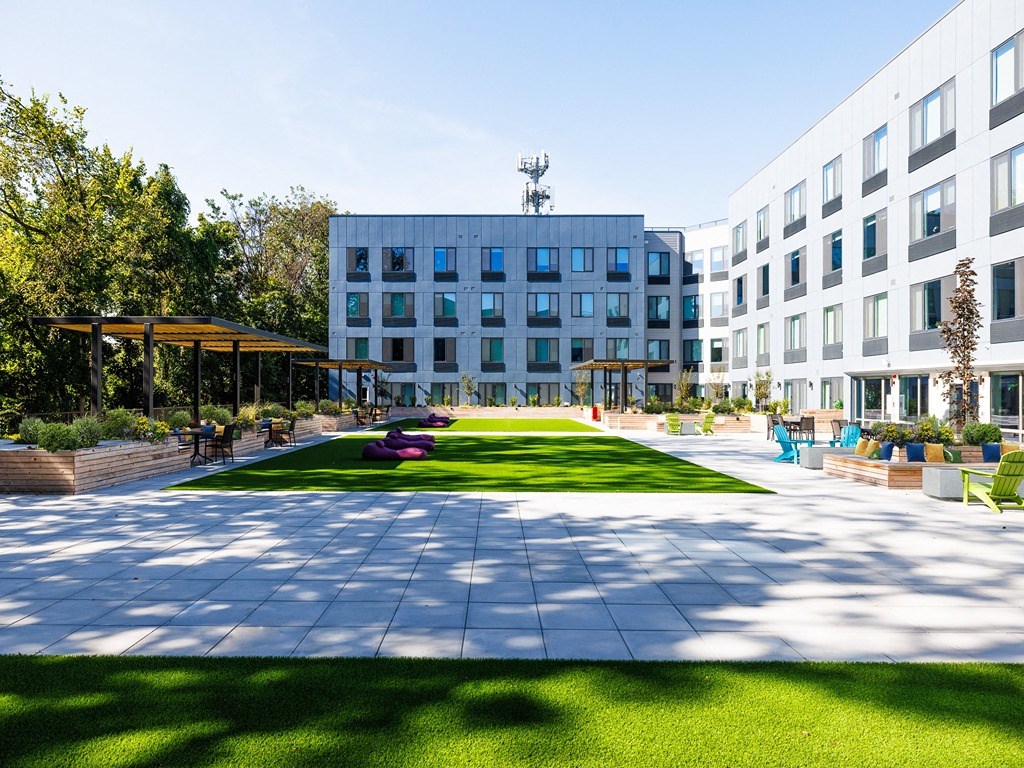 a courtyard with a lawn in front of a building