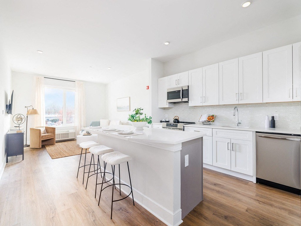 a kitchen with a large island and white cabinets