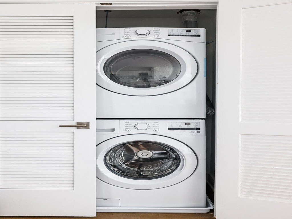 a white washer and dryer in a white closet