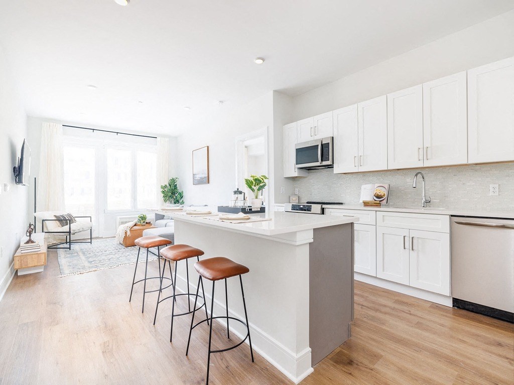 a kitchen with a large island with three stools