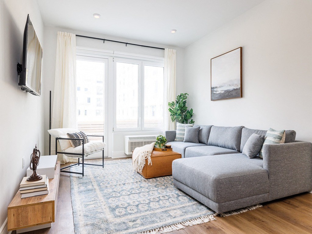 a living room with a gray couch and a large window