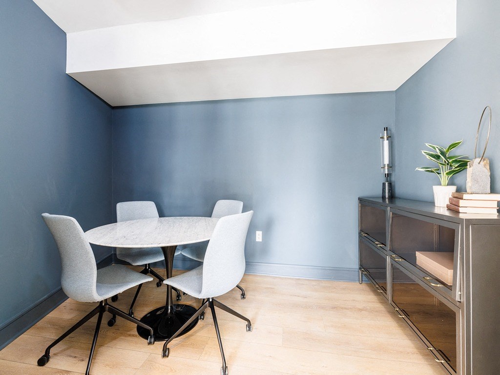 a dining room with a table and chairs and a blue wall