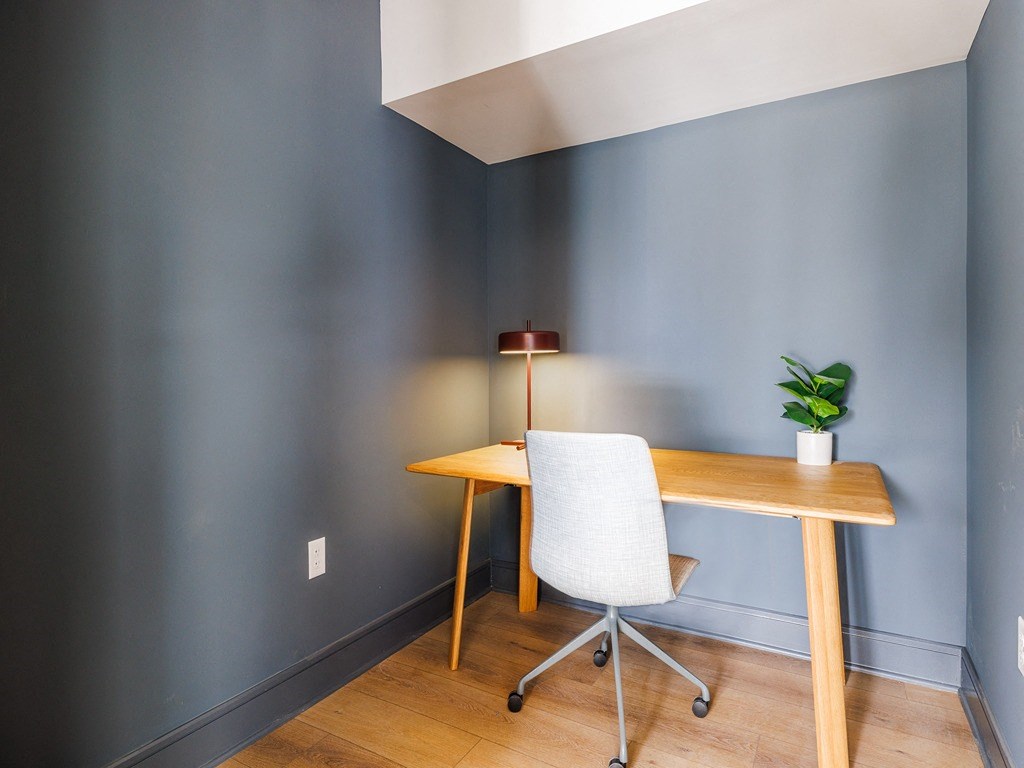 a desk and a chair in a room with blue walls
