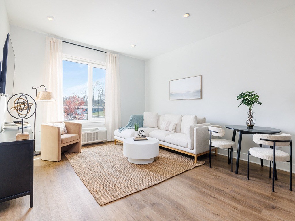 a living room with a white couch and a table and a large window
