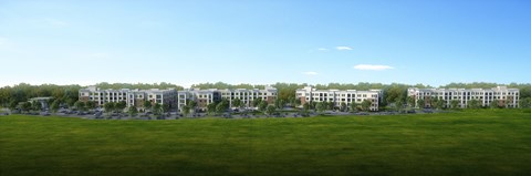 A large grassy field with a row of buildings in the distance at Manor East Apartments, Manor, 78653