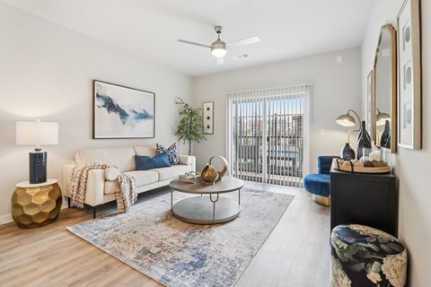 A living room with a white couch, a coffee table, and a painting on the wall.