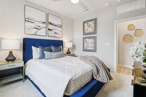 A bedroom with a large bed and a painting on the wall.