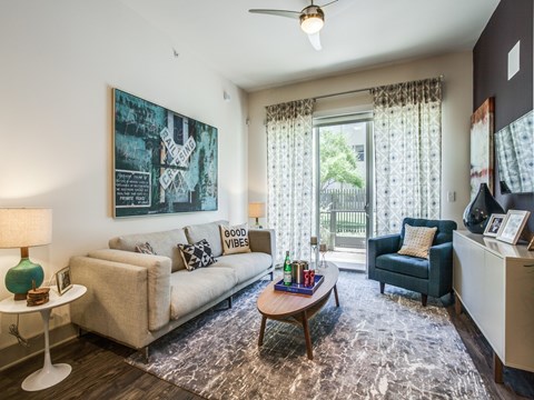 A living room with a couch, a chair, a table, and a painting on the wall.
