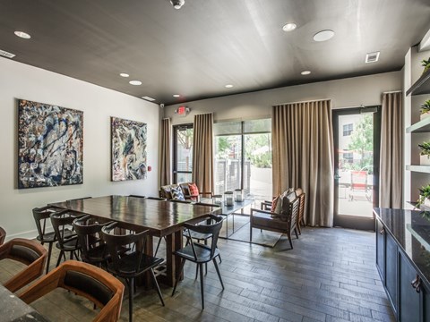 A dining room with a large table and chairs.