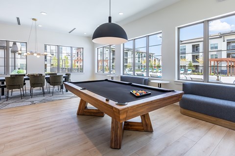 A pool table in a room with a view of the city.