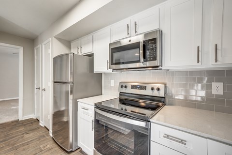 A kitchen with white cabinets and stainless steel appliances.