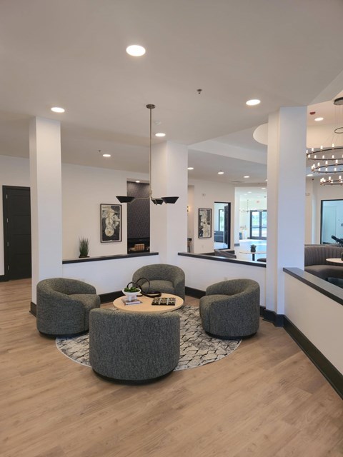 A modern living room with a round coffee table and grey armchairs.