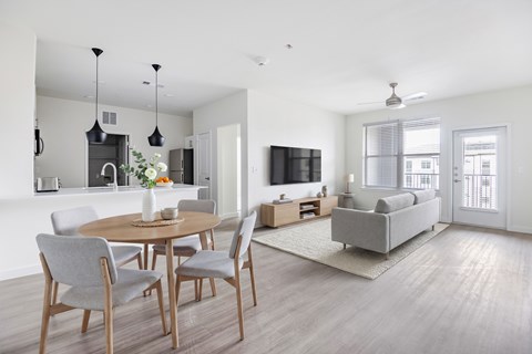A modern dining room with a round table and grey chairs.
