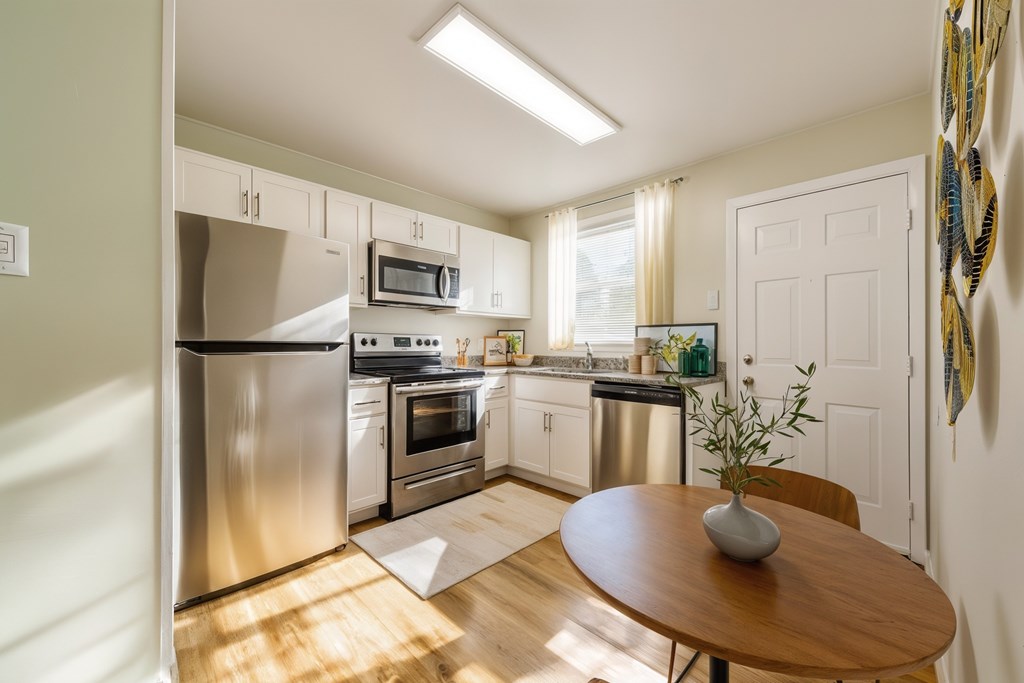 A kitchen with a table and chairs in the middle of the room.