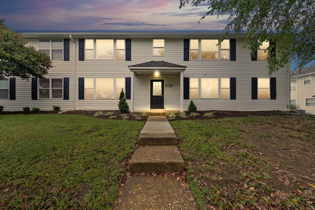 A building with a front yard and a walkway leading to the entrance.