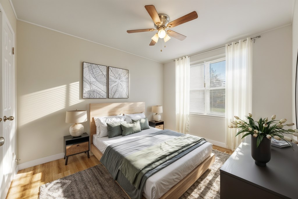 A bedroom with a bed, nightstand, and a ceiling fan.
