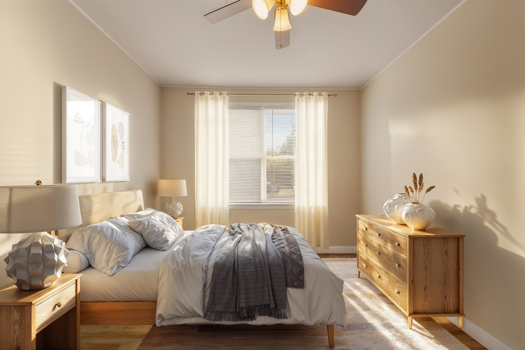 A bedroom with a bed, nightstand, and a ceiling fan.