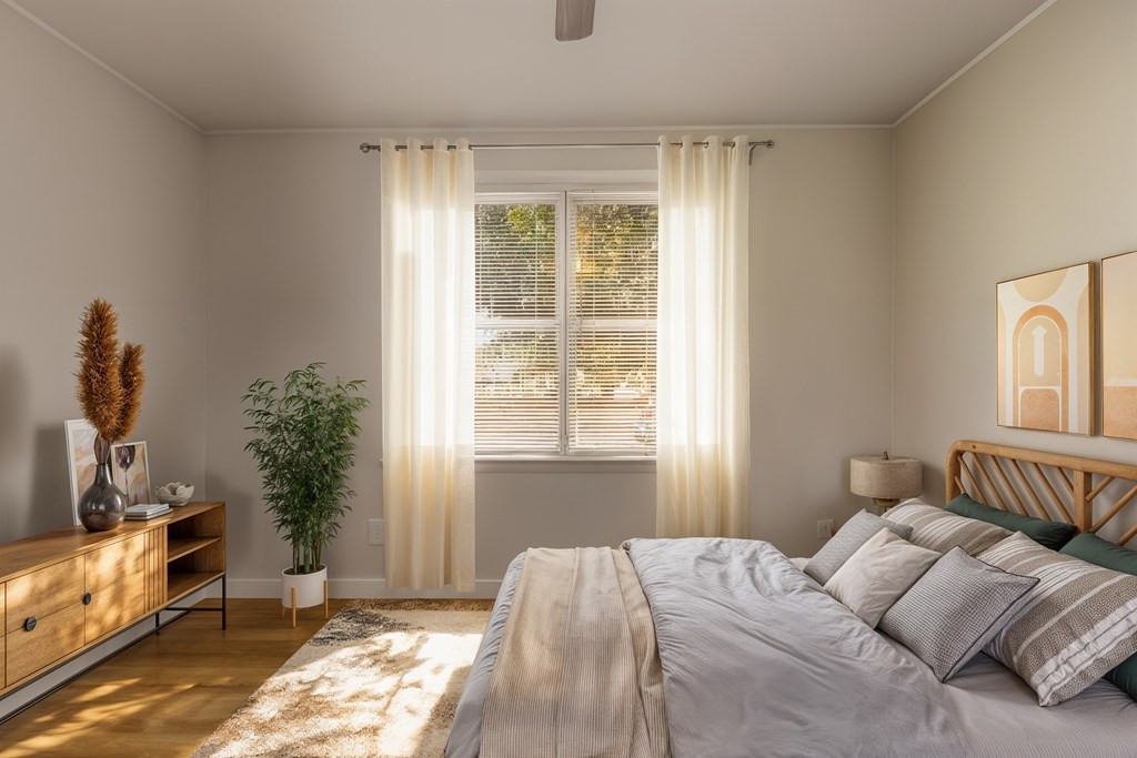 A bedroom with a large bed and a potted plant.
