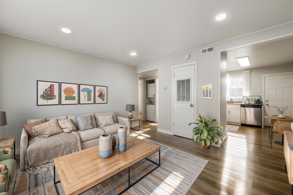 A living room with a couch, a coffee table, and a painting on the wall.