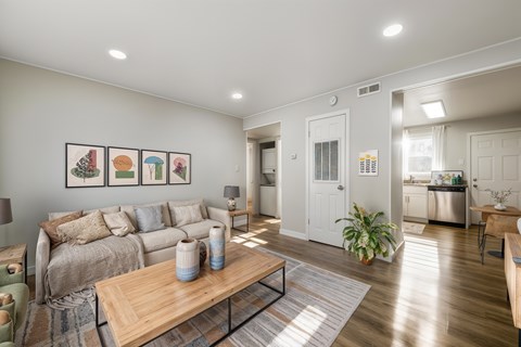 A living room with a couch, a coffee table, and a painting on the wall.