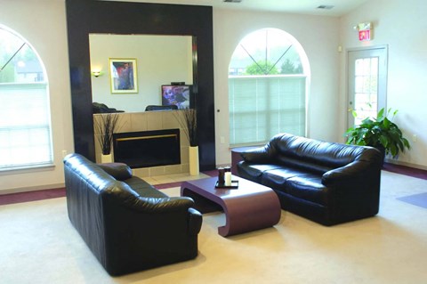 a living room with black leather furniture and a fireplace