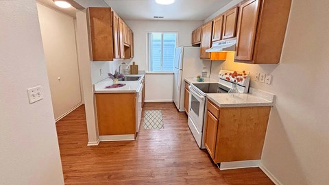 a kitchen with wooden cabinets and white appliances