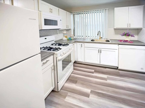 a kitchen with white cabinets and a stove and a refrigerator