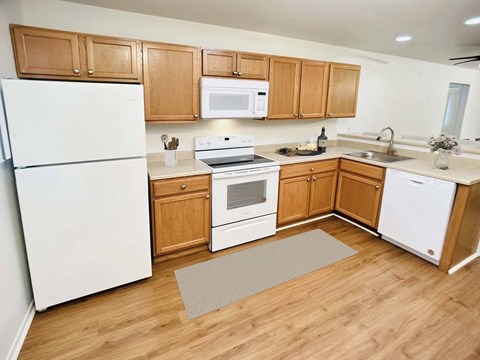 a kitchen with white appliances and wooden cabinets