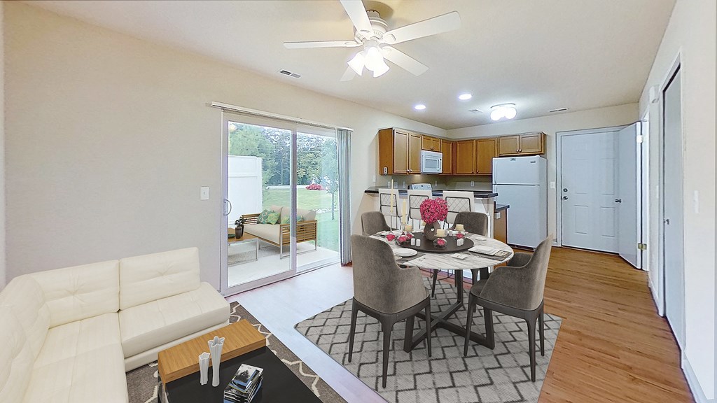 a living room and kitchen with a table and chairs