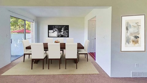 A dining room with a table and chairs.