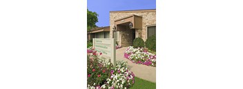 a sign in front of a building with flowers