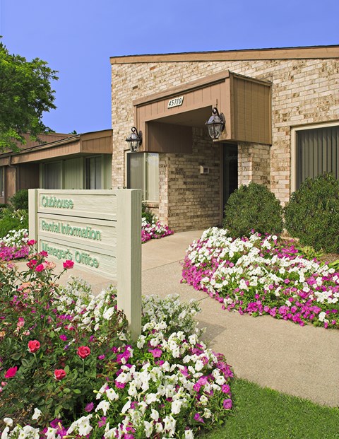 a sign in front of a building with flowers