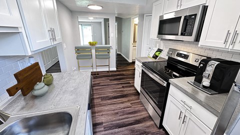 a kitchen with stainless steel appliances and white cabinets