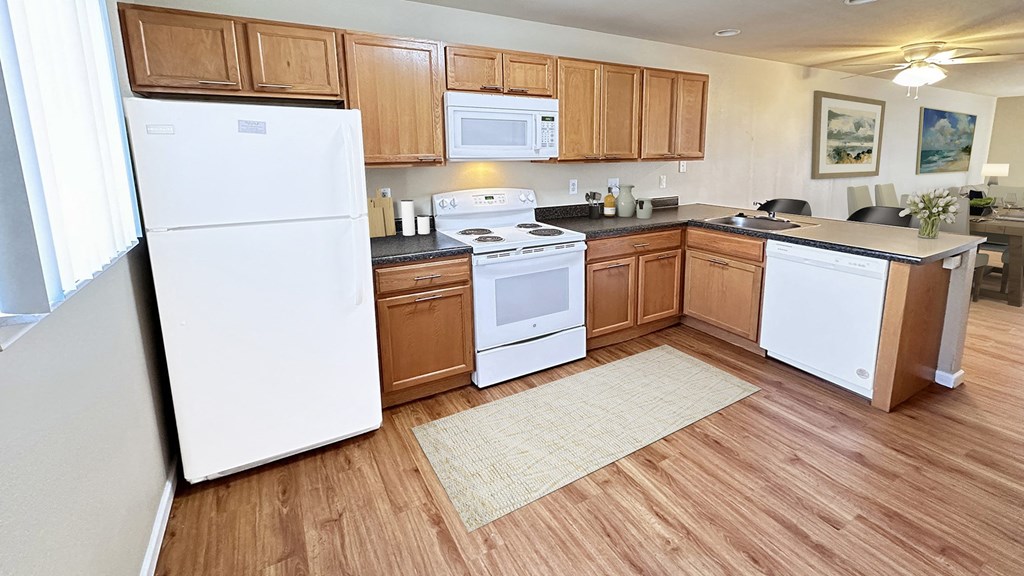a large kitchen with white appliances and wooden cabinets