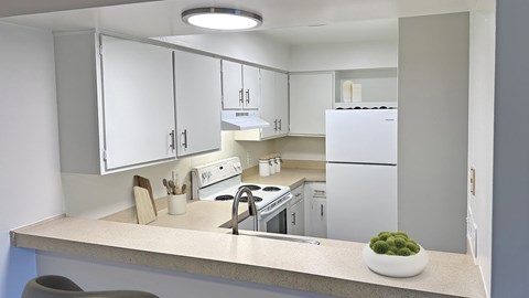 A modern kitchen with white appliances and cabinets.