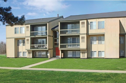 A large apartment building with a red door and balconies.