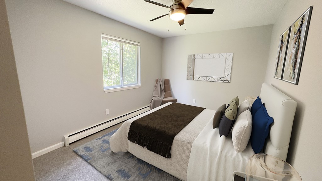 A bedroom with a bed, pillows, and a ceiling fan.