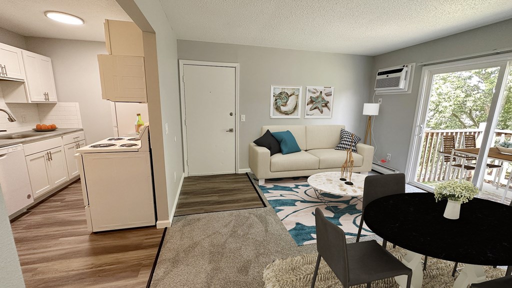 A living room with a couch, a dining table, and a kitchen area.